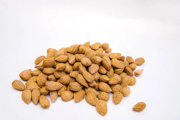 Inshell almonds on a white background. Almonds are arranged in a pile.Almond nut with texture.