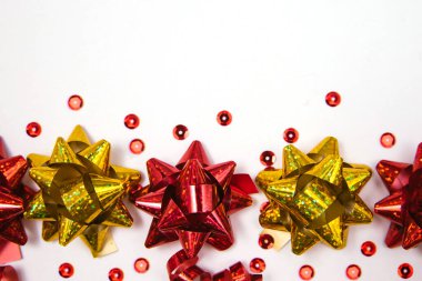 Beyaz bir arka planda hediye yayları. Konfeti ve şekerler dağınık. Noel ve yeni yıl. Metin için boş boşluk.