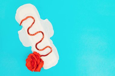 Mavi arka planda kadın dolgusu. Tıbbi konsept fotoğraf. Jinekolojik adet döngüsü. Kritik günlerde kadın hijyeni.