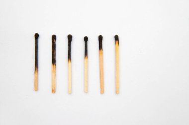 Kibritleri yakmanın farklı aşamaları. Eşleşmeler beyaz arkaplanda bir sırada duruyor.