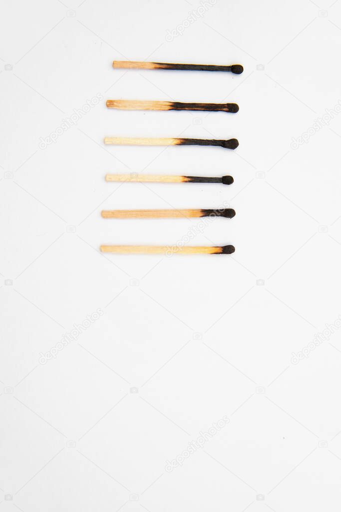 Different stages of burning matches. Matches stand in a row on a white background.