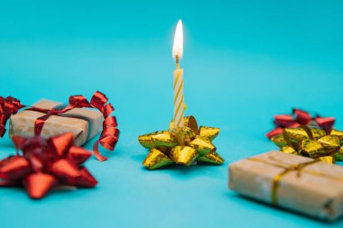 Kutlama mumu mavi bir arka planda ambalajda duruyor. Tatil için bir hediye..