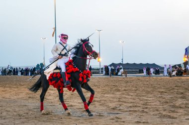 Genç erkek Suudi Arabistan at binicileri iş başında. Şehir: Dammam, Ülke: Suudi Arabistan. 5 Ocak 2019.