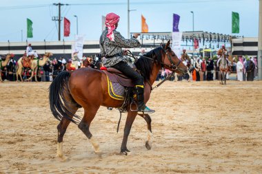 Genç erkek Suudi Arabistan at binicileri iş başında. Şehir: Dammam, Ülke: Suudi Arabistan. 5 Ocak 2019.