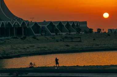 Al Khobar Corniche 'in gün doğumunun siluet görüntüsü. Şehir Khobar, Suudi Arabistan. (Seçici odaklı arka plan bulanık)