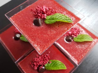 Tatlı, panna cotta çilek bardak çilek, nane yaprakları unsurları ile beyaz ve kırmızı ile dolu.