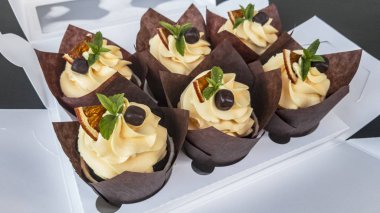 Nane, siyah çikolata, beyaz ambalajsiyah bir masada sarı limon dolulimon ile Gıda tatlılar cupcakes. Pakette tatlılar, naneli tatlı. Birçok tatlılar