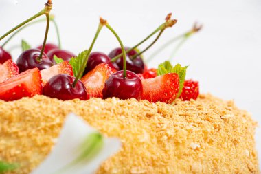 Güzel bir Napolyon pastası, çilek ve kirazla karıştırılmış hafif arkaplanda nane şekeri.