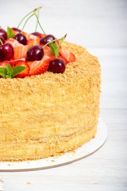 Güzel bir Napolyon pastası, çilek ve kirazla karıştırılmış hafif arkaplanda nane şekeri.