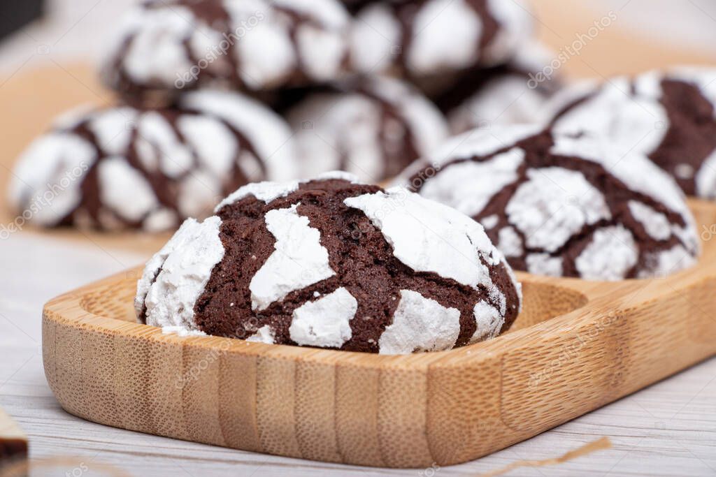 Marble chocolate cookies on a wooden stand in powder