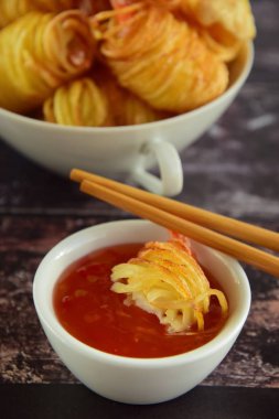 Patates İpli Karidesler. Asya usulü yemekler, patates ipine sarılı kral karidesler ve acı biber sosuyla servis edilen kızarmış patates.