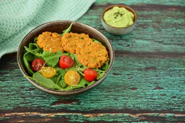 Kiraz domatesli roka salatası, susam tohumu, falafel ve guacamole