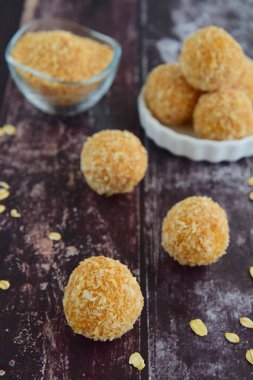 Tatlı patates yulaflı hindistan cevizi enerji topları koyu ahşap arka planda