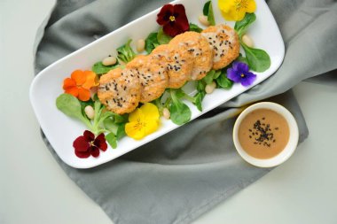 Beyaz fasulye karnabahar köfteleri tarla salatasında fıstıklı tahini sosuyla servis ediliyor.