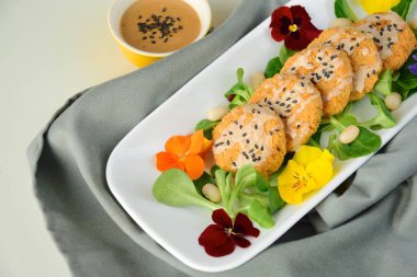 Beyaz fasulye karnabahar köfteleri tarla salatasında fıstıklı tahini sosuyla servis ediliyor.