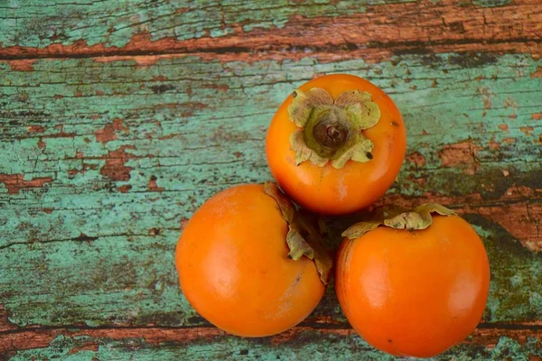 Reife Bio Persimmons Auf Dem Grünen Brett lizenzfreie Stockbilder