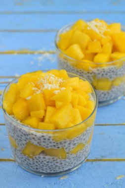 Hindistan cevizli mango chia tohumu pudingi. Mavi arkaplan