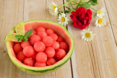 Karpuz kabında karpuz topları, papatya çiçeğiyle süslenmiş.