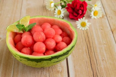 Karpuz kabında karpuz topları, papatya çiçeğiyle süslenmiş.