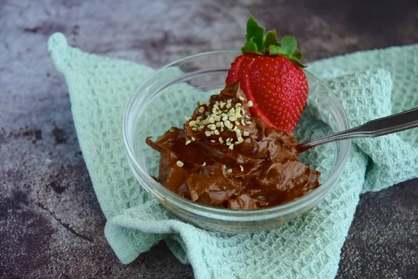 Chocolate avocado mousse with hemp seeds and strawberry