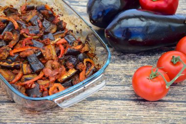Fırında patlıcan, domates soslu dolmalık biber ve susam tohumlu ve maydanozlu garnitür. Sarı arkaplan