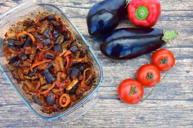 Fırında patlıcan, domates soslu dolmalık biber ve susam tohumlu ve maydanozlu garnitür. Sarı arkaplan