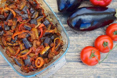 Fırında patlıcan, domates soslu dolmalık biber ve susam tohumlu ve maydanozlu garnitür. Sarı arkaplan