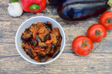 Fırında patlıcan, domates soslu dolmalık biber ve susam tohumlu ve maydanozlu garnitür. Sarı arkaplan