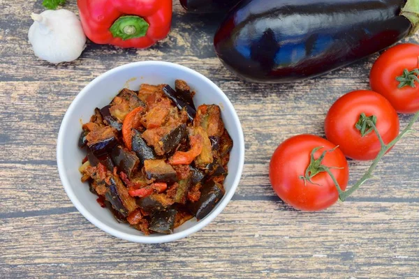 Fırında patlıcan, domates soslu dolmalık biber ve susam tohumlu ve maydanozlu garnitür. Sarı arkaplan