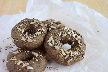 Vegan gluten free bagels topped with sunflower seeds, flax seeds and sesame seeds. Spread with nut butter. Healthy breakfast food.