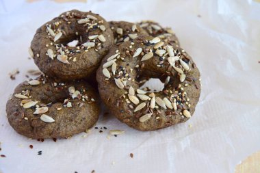 Vegan gluten free bagels topped with sunflower seeds, flax seeds and sesame seeds. Spread with nut butter. Healthy breakfast food.