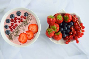 Çilekli meyve suyu kasesi, yaban mersini, kırmızı frenk üzümü ve chia çekirdeği.