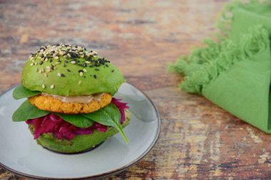 Nohut köftesi, tahin, ıspanak, kırmızı lahana ve susam tohumlu vegan avokado burgeri.