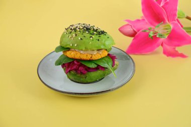 Kırmızı lahana, ıspanak, nohut karnabaharı ve susam tohumlu tahin serpiştirilmiş sağlıklı vegan avokado burgeri..