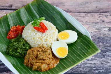 Endonezya mutfağı Nasi Padang, sığır etli pilav Rendang, tuzlu ançüez fıstığı, haşlanmış yumurta, ezilmiş kasava yaprakları ve Sambal.