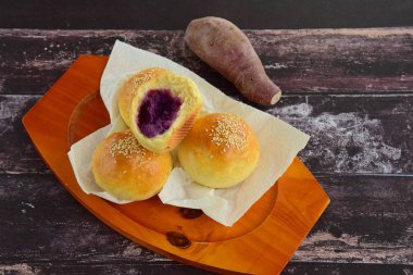 Mor tatlı patates püresiyle doldurulmuş susamlı ekmek çörekleri.