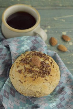 Ev yapımı çikolatalı çörekler, badem ve çikolata parçacıkları, kahve ile servis edilir.