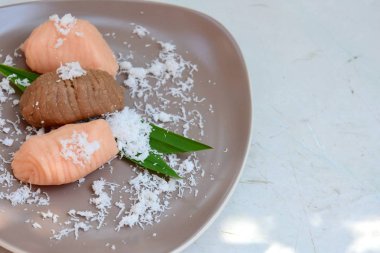 Getuk Lindri. Ceviz ezmesinden yapılmış Java tatlı atıştırmalığı, rendelenmiş hindistan ceviziyle sarılmış ve yenmiş..