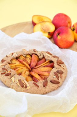 Şeftalili ve nane yaprağıyla süslenmiş badem fıstıklı bir galette. Düz yatıyordu