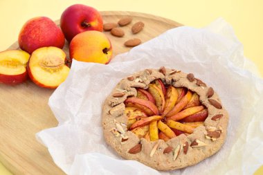 Şeftalili ve nane yaprağıyla süslenmiş badem fıstıklı bir galette. Düz yatıyordu