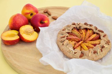 Şeftalili ve nane yaprağıyla süslenmiş badem fıstıklı bir galette. Düz yatıyordu