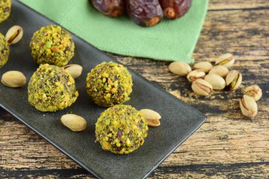 Pistachio Çikolata Enerji Topları ile Tahta Arkaplanda Randevu. Vejetaryen atıştırması