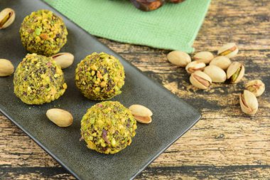 Pistachio Çikolata Enerji Topları ile Tahta Arkaplanda Randevu. Vejetaryen atıştırması