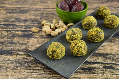 Pistachio Çikolata Enerji Topları ile Tahta Arkaplanda Randevu. Vejetaryen atıştırması