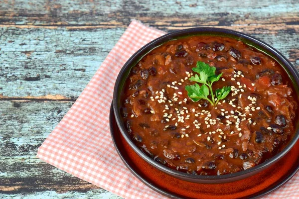 Ev yapımı vejetaryen biberli siyah fasulye çorbası susamlı garnitür ve doğranmış maydanoz. 