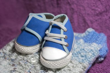 Beyaz arka planda mavi ve siyah bebek ayakkabısı