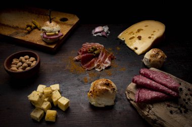 Peynir, ekmek, yer fıstığı, sarımsak, zeytin, salam ve reçel ile ahşap bir masa