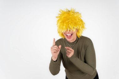 Abartılı bir jest ve canlı bir perukla etkileyici bir kadın.