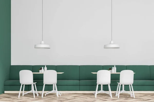Front view of a green and white wall cafe interior with green sofas and white chairs. A close up. Concept of business lunch. 3d rendering mock up