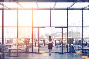 Dikiz bir cam çatı restoran terası bulunan bir iş kadını. Beyaz duvarları, ahşap zemin ve onlara yakın siyah kanepe tablolarla. Cityscape. 3D render sahte kadar çift tonlu görüntü pozlaması